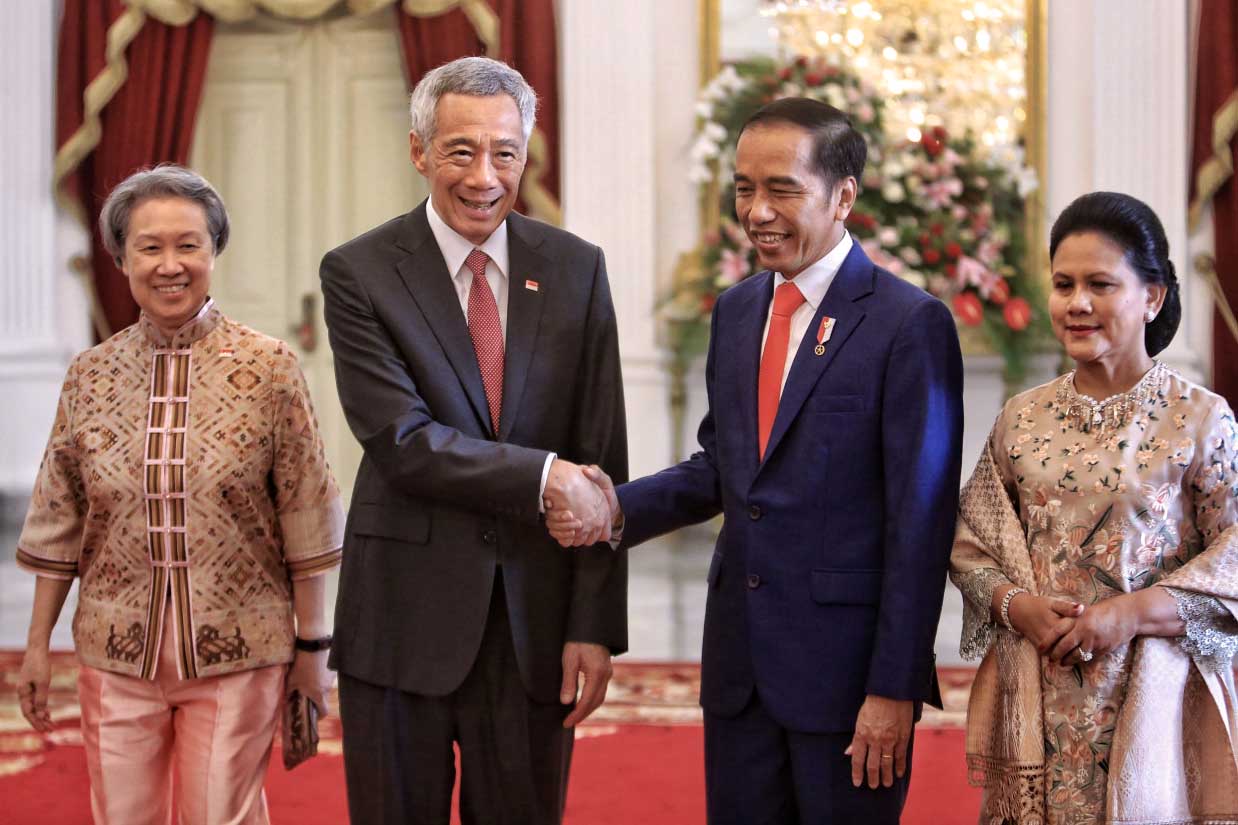 President Joko "Jokowi" Widodo (second right), accompanied by First Lady Iriana (right), shakes hands with Singaporean Prime Minister Lee Hsien Loong and his wife Ho Ching before his inauguration ceremony at Merdeka Palace in Jakarta on Sunday. JP/Seto Wardhana