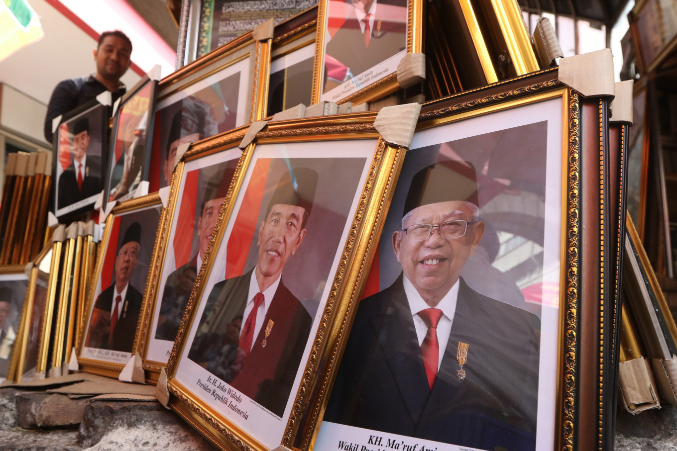 A resident browses through framed photos of President Joko “Jokowi” Widodo and Vice President Ma’ruf Amin at a stall in Pasar Baru, Central Jakarta, on Thursday. Issued by the State Secretariat, the official photo is available for free download at setneg.go.id. JP/Dhoni Setiawan