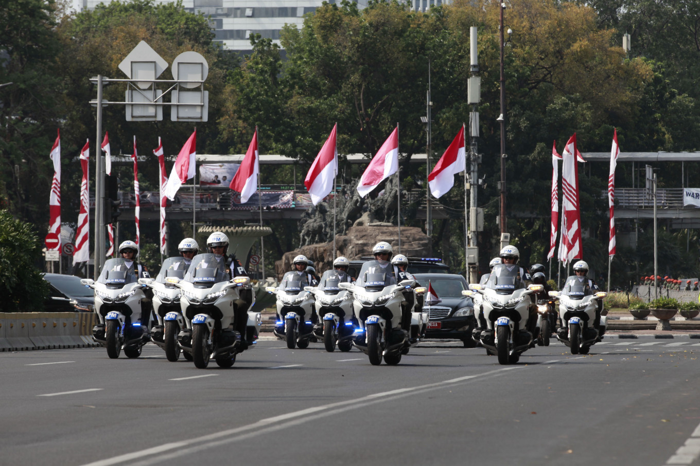 A convoy of vehicles carrying the President passes the front of Bank Indonesia Fountain, Jakarta, on its way to the inauguration ceremony. JP/Narabeto Korohama