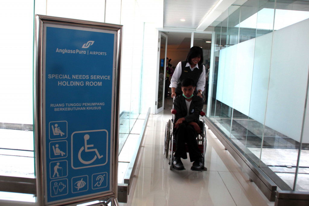 An officer of Ahmad Yani airport in Semarang, Central Java, aids a disabled passenger into the airport's special needs room on Oct. 21, 2019.