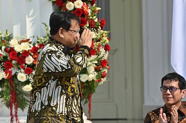 Indonesian Defense Minister Prabowo Subianto gestures toward President Joko "Jokowi" Widodo (unseen) during the unveiling of his new Cabinet on the steps of the Merdeka Palace in Jakarta on Oct. 23.