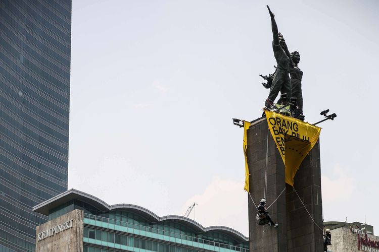 A Greenpeace banner hangs from the Welcome Monument at the Hotel Indonesia traffic circle in Central Jakarta. 