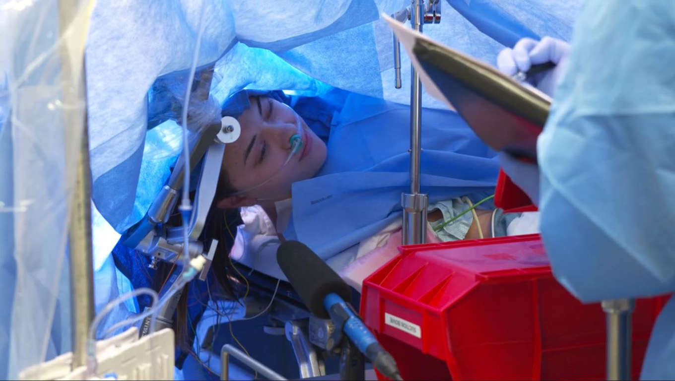 In this October 29, 2019, still image taken from a video courtesy of Methodist Dallas Medical Center in Dallas, Texas, Jenna Chardt, 25, remains conscious while neurosurgeons perform brain surgery. 