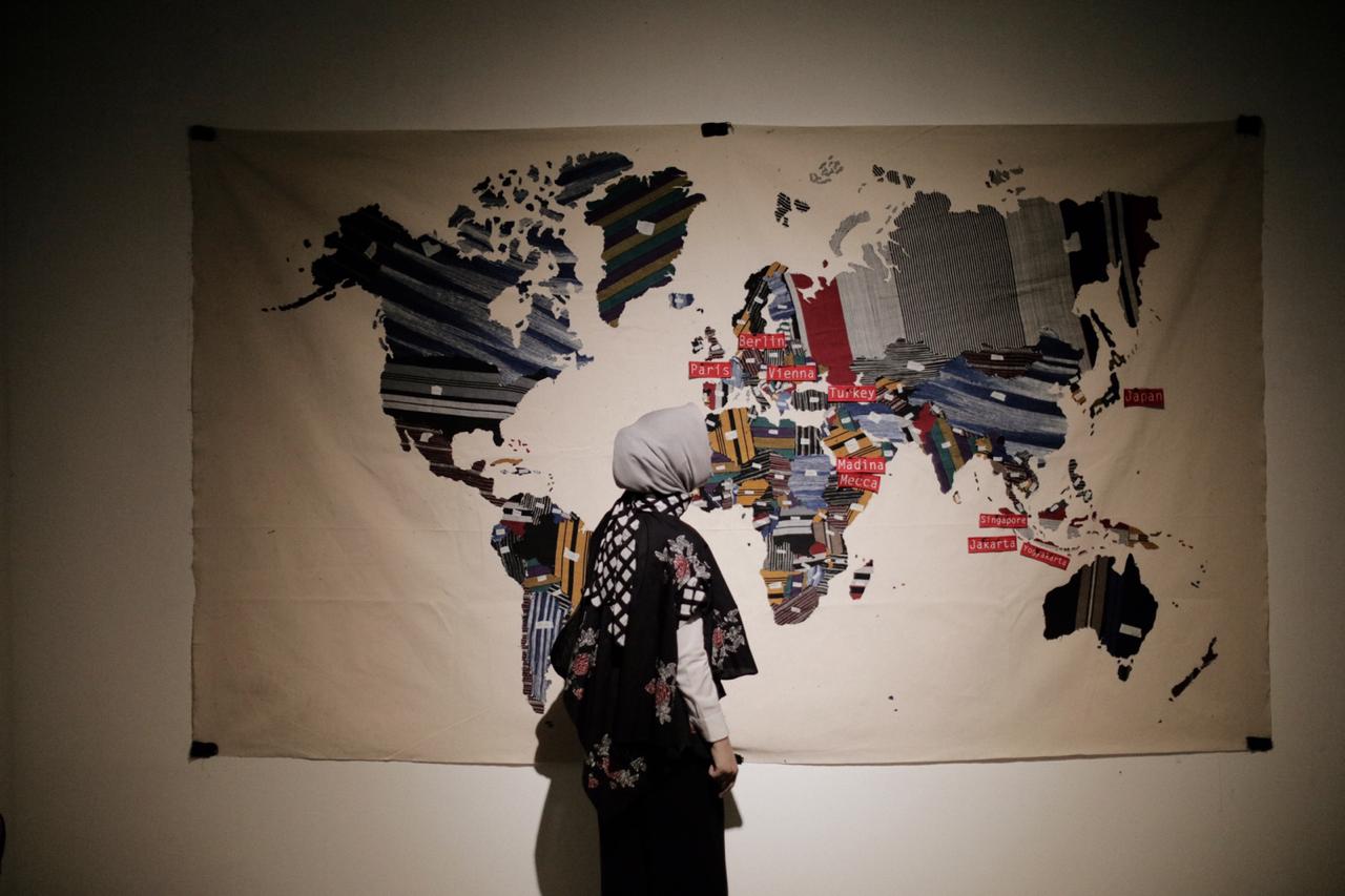 A visitor looks at a world map with marks on the countries visited by fashion designer Lulu Lutfi Labibi. The world map was showcased in an exhibition that depicts Lulu's eight-year journey in the fashion industry.