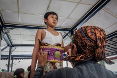 Rizki is assisted by Suyatiman in wearing Javanese traditional attire. The waist strap bears the Praja Cihna (Haba), the official symbol of Kraton Ngayogyakarta Hadiningrat. JP/ Anggertimur Lanang Tinarbuko