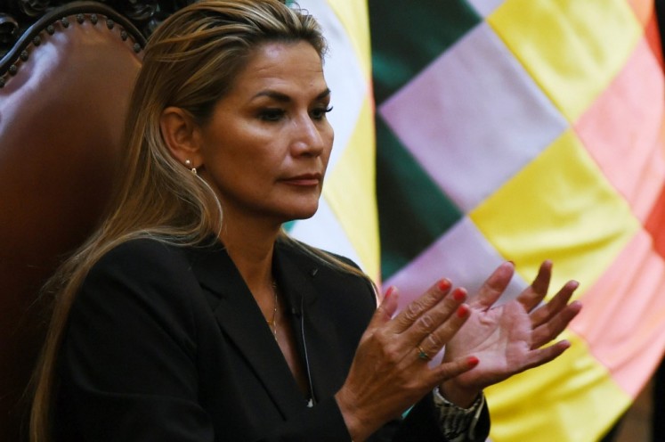Bolivia's interim president, Jeanine Anez applauds after taking oath to the military command during her first day in power, at the Quemado presidential palace in La Paz, on November 13, 2019. Anez, who declared herself interim president before her claim was endorsed by the constitutional court, arguing that her succession was necessitated by the resignations of those above her in the government hierarchy, will try to fill the power vacuum left by Evo Morales's abrupt resignation, as the former leader denounced what he described as a 