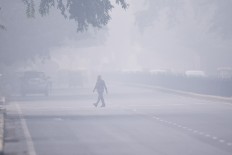 A man crosses a street in smoggy conditions in New Delhi on Nov. 4, 2019. Nearly 90 percent of the 200 cities beset by the world's highest levels of deadly micro-pollution are in China and India, with most of the rest in Pakistan and Indonesia, researchers reported Tuesday.