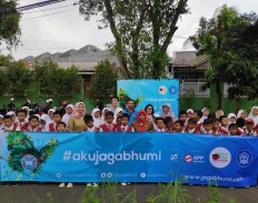 Young and green: Students of Kemirimuka I elementary school, Depok, pose for a photo (above) at the end of the Goes To School green campaign on Tuesday. The students enthusiastically participated in the event, organized jointly by the Botanical Gardens Foundation, Diandra Promosindo and APP Sinar Mas.
