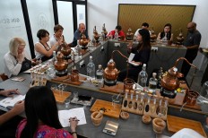 In this photo taken on October 13, 2019, Jamie Koh (center R), founder of the Brass Lion Distillery, teaches a gin-making course in Singapore. 