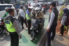 Jakarta Police officers and Jakarta Transportation Agency personnel stop a motorcyclist using a designated cycle lane in Fatmawati in South Jakarta on Tuesday. 