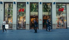People walk in front of H&M shop located at Passeig de Gracia, one of the major avenues in Barcelona