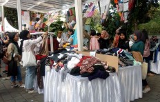 Visitors look through secondhand clothes displayed at the Pasar Raia (Raia Market) garage sale in Taman Suropati, Central Jakarta, on Saturday. The event aims to promote sustainable fashion to the public. 
