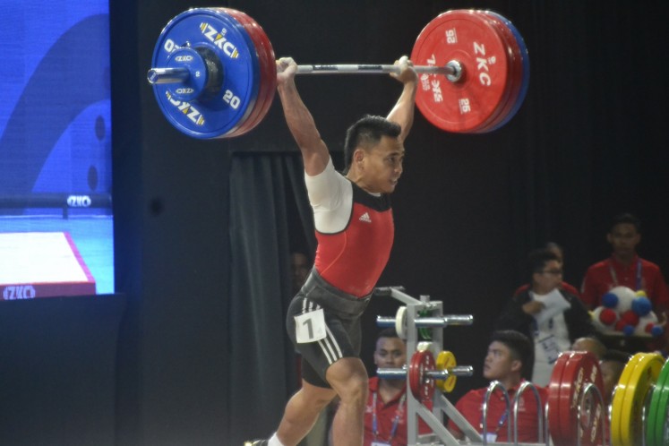 Indonesian weightlifter Eko Yuli Irawan tries hard to make a successful lift at the clean and jerk category at the men's 61 kilograms in the 30th Southeast Asian Games in the Philippines on Monday, Dec. 2, 2019. Eko is bringing a gold medal home from the event.