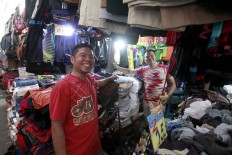 Hustling: Two vendors pose in front of their kiosks at Poncol Market, Central Jakarta. JP/Narabeto Korohama