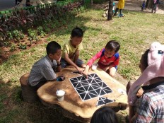 Playtime: Toro (middle) plays "Damdas tiga batu" with his friends and one of his friend's father at Tomang Rawa Kepa Park, West Jakarta, on Sunday. 