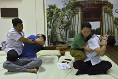 In this photo taken on December 3, 2019 a Thai instructor (L) trains his student from Hong Kong (R) at the Wat Po Thai traditional massage school, outside the Wat Po temple complex in Bangkok. 