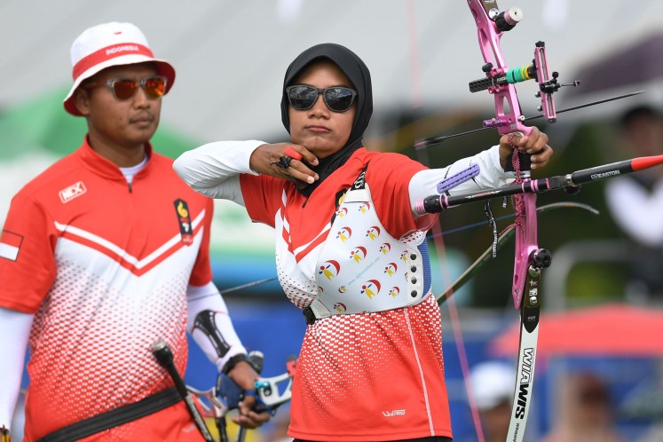 Indonesian archer Choirunisa Diananda (right) releases an arrow as her teammate Riau Ega Agatha Salsabila (left) looks on, during the mixed team recurve final on Dec. 8, 2019 at the 30th SEA Games in Pampanga, the Philippines. The Indonesian pair won silver after losing to Vietnam's Loc Thi dao and Nguyen Hoang Phi Vu.