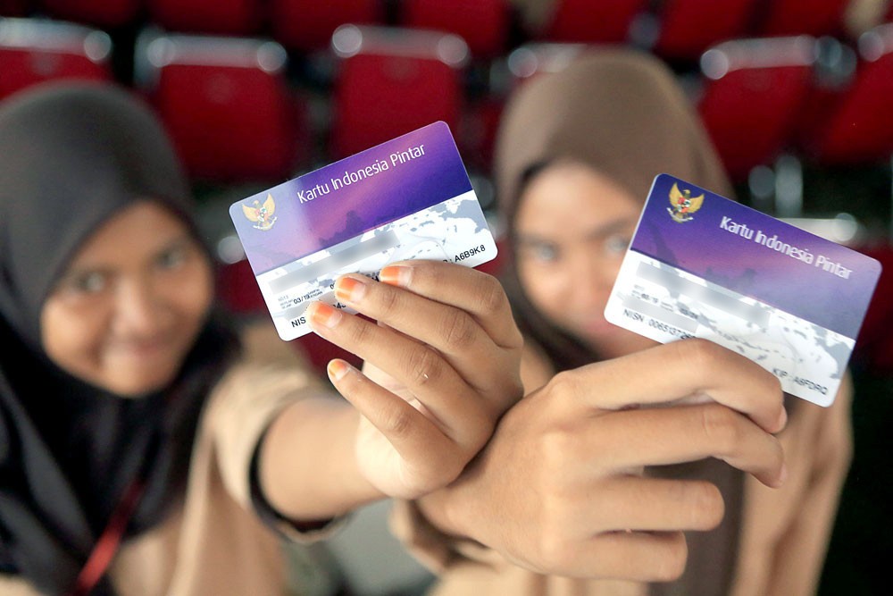 Secondary school students show their government-issued Indonesia Smart Card (KIP) on July 8, 2020 in Jakarta. The KIP provides cash assistance to students from low-income families to buy books and other school supplies.