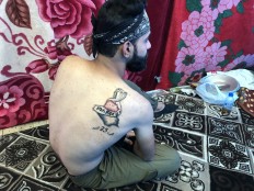 An Iraqi man displays his tattoo in the capital Baghdad on December 9, 2019. 