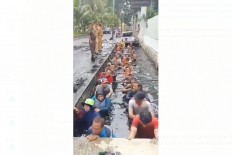 A screenshot of a viral video shows Public Facility Maintenance Agency (PPSU) officers in a gutter in Jelambar, West Jakarta. Information is conflicting on whether the activity was part of a contract extension test, but the Jakarta governor has said that all those involved in administering the activity would be dismissed.