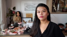 Singaporean artist Qixuan Lim poses next to cans containing tiny cherubic fetus heads, arms and legs or other human body parts, which she sculpted using clay and cosmetic paint, in Singapore, on October 26, 2019. 