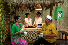 Vendors and patrons smile in the interior of a ‘warung’ (sidewalk shop) at the opening of the National Warung Movement Festival in Lapangan Banteng, Central Jakarta, on Dec. 14.