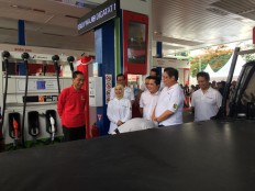 President Joko “Jokowi” Widodo (left, in red), state-owned oil and gas holding company Pertamina president director Nicke Widyawati (center, wearing yellow veil) and several ministers symbolically kick off the B30 policy at a Pertamina gas station on Jl. MT. Haryono in Jakarta on Dec. 23, 2019.