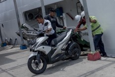 Attendants help unload a motorcycle from the ferry at Pulau Pramuka docks. JP/Rosa Panggabean
