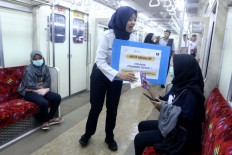 A Kereta Commuter Indonesia (KCI) official distributes pamphlets to inform train passengers about what to do in an occurrence of sexual harassment at Jakarta Kota Station, Central Jakarta, on Dec. 27, 2019. The campaign aims to  encourage victims and witnesses to act against perpetrators.