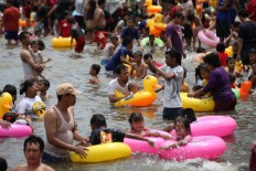 Hundreds of visitors enjoy Karnaval Beach in Ancol, North Jakarta, on Dec. 30, 2019.