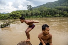 Two boys swim in the shallows of the Batang Hari River. JP/Ramadhani