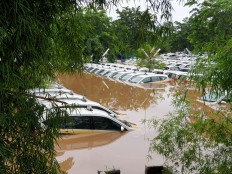 Cars are seen partially submerged in water at the Express taxi pool in Tanah Kusir, South Jakarta, on Jan. 1. JP/R Berto Wedhatama