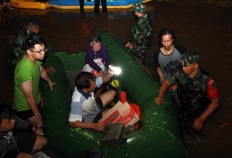 Indonesian Military (TNI) personnel help evacuate people trapped in their inundated homes in the Ciledug Indah housing complex in Tangerang city, Banten on, Jan. 1. 