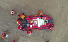 A search and rescue team rescues flood victims using a rubber boat on Jl. Jatinegara Barat in Kampung Pulo, Jakarta, on Thursday, Jan. 2, 2020 