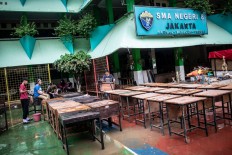 Teachers and  students of SMA 8 state high school clean their school after it was flooded in Bukit Duri, Tebet, South Jakarta on Saturday.