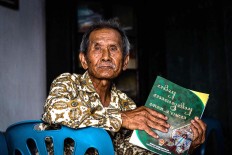 Rama Dwijo holds a Javanese textbook. JP/Anggertimur Lanang Tinarbuko