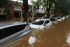 Dozens of cars are submerged in Kemang, South Jakarta, on Jan.1. After the flooding subsided, many car owners flocked to repair shops to fix them.