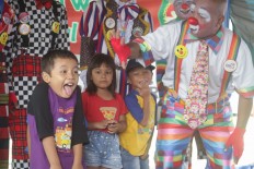 Clowns from Aku Badut Indonesia (ABI) play with children affected by recent flooding in a shelter in Pesanggrahan, Bintaro, South Jakarta on Sunday. . 