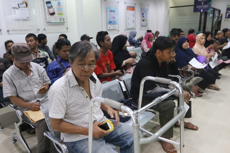 Applicants wait in line at the Health Care and Social Security Agency (BPJS Kesehatan) office in Matraman, Central Jakarta, On Nov. 11, 2019. 