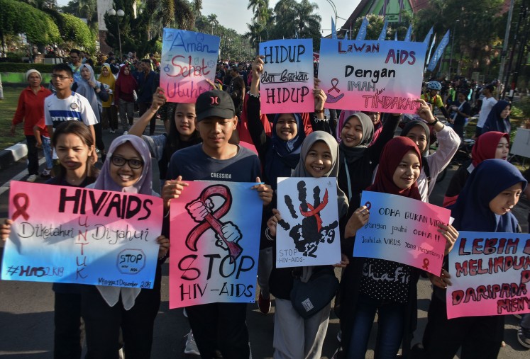 Annual reminder: Students hold up HIV/AIDS awareness posters in commemoration of World AIDS Day on Jl. Besar Ijen in Malang, East Java, on Dec. 1, 2019. 