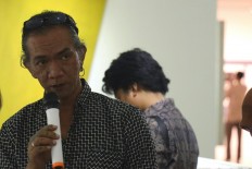 Painter Ugo Untoro speaks during the press tour of his latest exhibition. 