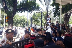Members of a group supporting Jakarta Governor Anies Baswedan rally inside the City Hall compound as anti-Anies demonstrators protest outside against the governor's handling of recent flooding on Tuesday.