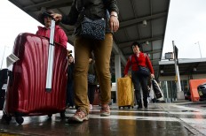 Arriving passengers make their way from Terminal 4 at the JFK airport in New York on October 11, 2014. US authorities have said they would start screening at three airports to detect travelers arriving via direct or connecting flights from Wuhan who may have symptoms of the new virus.