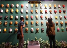Visitors are seen admiring Majapahit masks, which were created based on interpretations of ancient stupas and temples built in the era of the Majapahit and Singosari kingdoms.