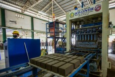 In this photo taken on January 17, 2020 workers at the Binan City Materials and Recovery Facility (MRF) monitor the brick making process from collected volcanic ash from the recent Taal volcano eruption to process them and turn them into cement bricks in Bian. Binan got coated with ash after nearby Taal Volcano erupted Sunday, but the local officials decided to put the dust to work rather than just cleaning it up. The fine grey powder is being mixed with locally collected plastic waste, as well as sand and cement, to form about 5,000 bricks per day. The blocks will be used for local building projects.
