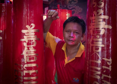 Pepen, who is not of Chinese descent, works at the temple and writes prayers on candles. He comes from Sukabumi, West Java, and has worked there for 20 years. JP/Bismo Agung