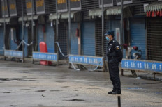 A security guard stands outside the Huanan Seafood Wholesale Market where the coronavirus was detected in Wuhan on Jan. 24, 2020.