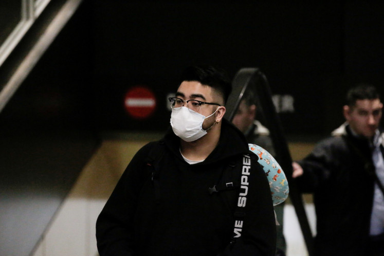 A traveler wearing a mask arrives on a direct flight from China, after a spokesman from the US Centers for Disease Control and Prevention (CDC) said a traveler from China had been the first person in the United States to be diagnosed with the Wuhan coronavirus, at Seattle-Tacoma International Airport in Washington, United States, on January 23, 2020. 