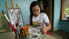 Filipina artist Janina Sanico uses volcanic ash she found in her yard to paint images of Taal volcano inside her home in Tanauan, Batangas Province, Philippines, on January 24, 2020. 