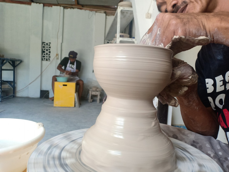 A Kaloka Pottery employee in the process of creating a product